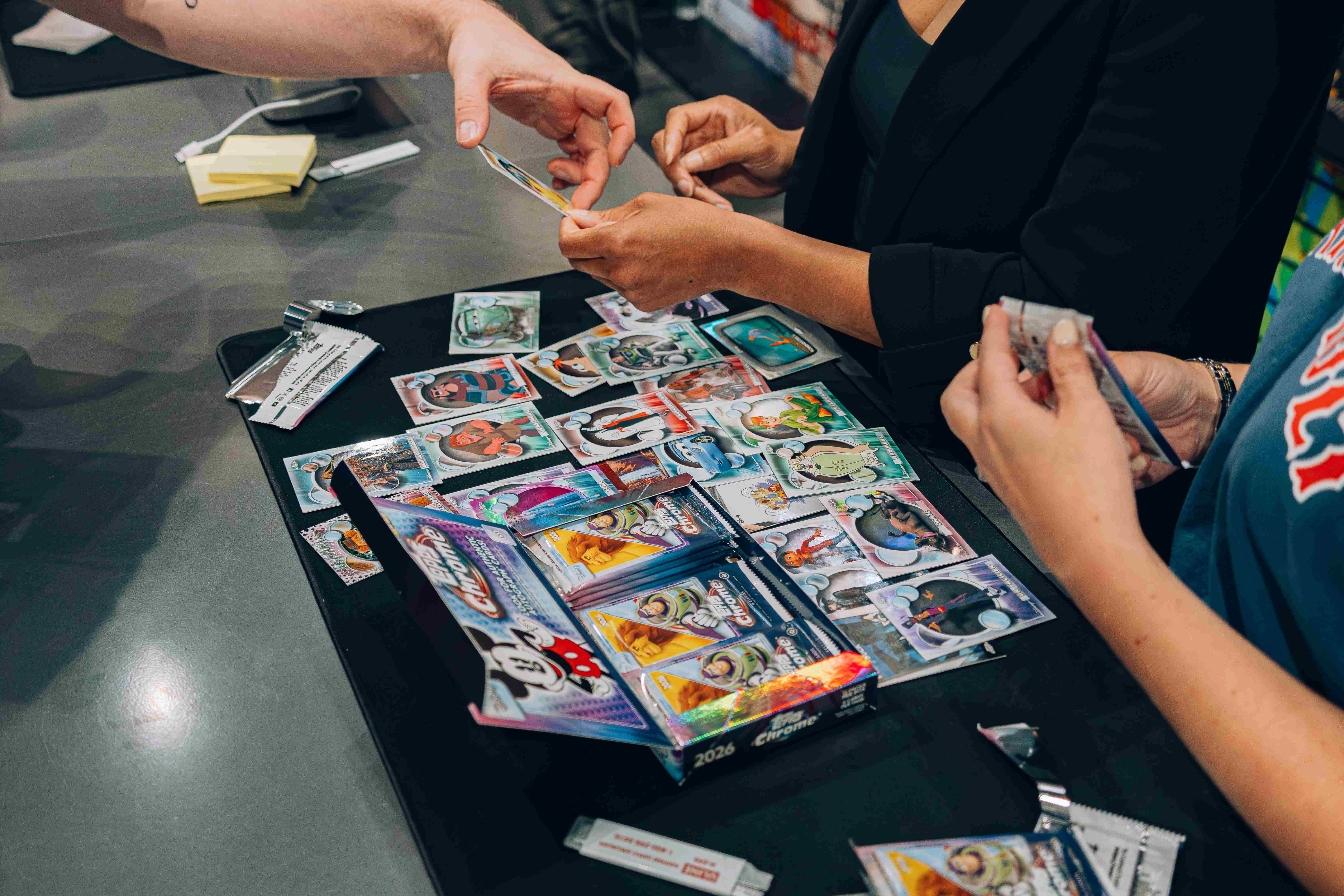 hands of people at card vault by tom brady looking at cards